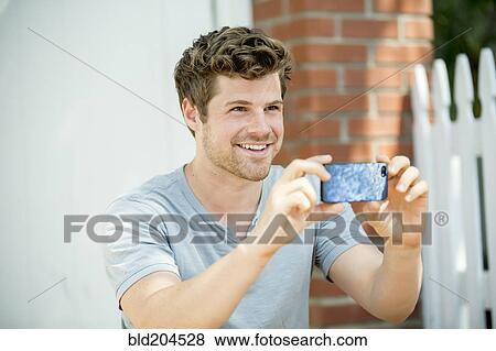 Stock Photo - Man using cell phone outdoors. Fotosearch