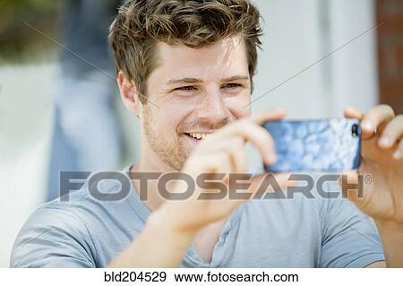 Stock Photo - Man using cell phone outdoors. Fotosearch