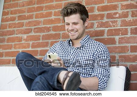 Man using cell phone outdoors View Large Photo Image Stock Photography - Man using cell phone outdoors. Fotosearch