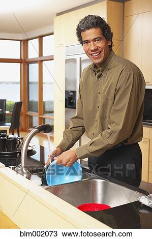 Man washing dishes in kitchen View Large Photo Image Stock Image - Man washing dishes in kitchen. Fotosearch