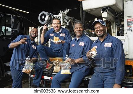 Stock Image - Mechanics eating lunch together. Fotosearch