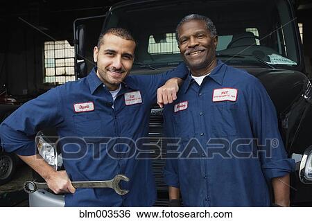 Stock Photograph - Mechanics standing in repair shop. Fotosearch