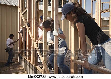 Stock Image - Men and women working at construction site. Fotosearch