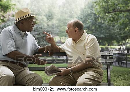 Stock Photography - Men arguing on park bench. Fotosearch