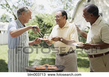 Men barbecuing in backyard View Large Photo Image Stock Image - Men barbecuing in backyard. Fotosearch