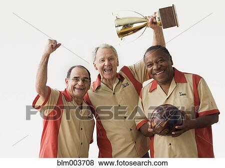 Stock Photo - Men in team uniforms holding bowling ball and trophy. Fotosearch