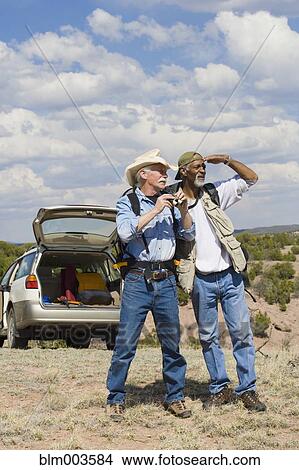 Picture - Men on remote roadside looking into distance. Fotosearch