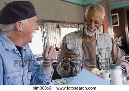 Men sitting at diner table View Large Photo Image Stock Image - Men sitting at diner table. Fotosearch