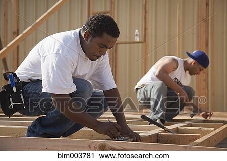 Stock Image - Men working at construction site. Fotosearch