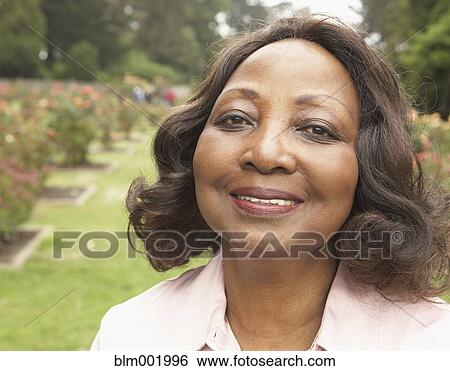 Middle-aged African woman smiling outdoors View Large Photo Image Stock Photograph - Middle-aged African woman smiling outdoors. Fotosearch