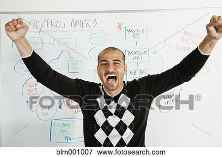 Stock Photo - Middle Eastern businessman cheering in front of whiteboard. Fotosearch