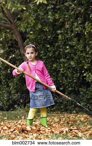Picture - Middle Eastern girl raking leaves. Fotosearch