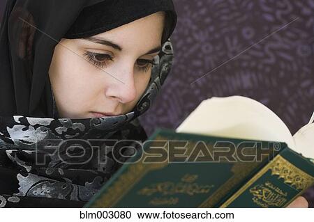 Stock Image - Middle Eastern teenager reading book. Fotosearch