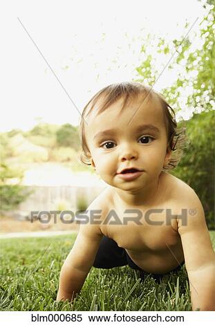 Stock Photography - Mixed race baby boy crawling in grass. Fotosearch
