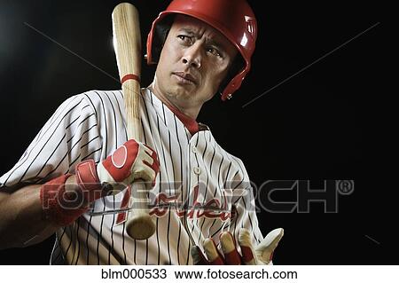Stock Image - Mixed race baseball player holding bat. Fotosearch