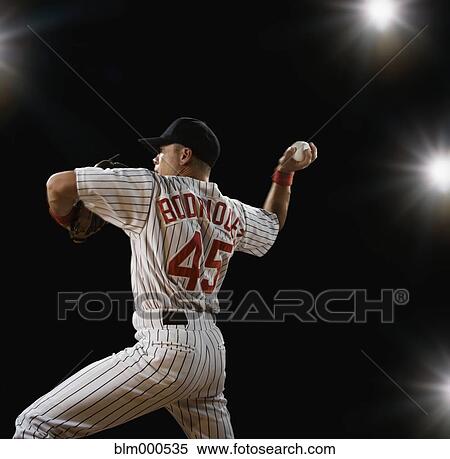 Stock Photography - Mixed race baseball player pitching. Fotosearch