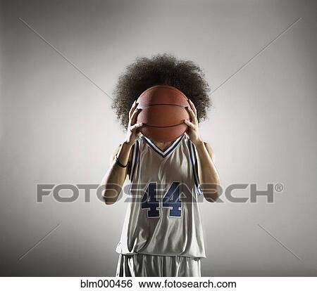 Stock Photograph - Mixed race basketball player holding basketball. Fotosearch
