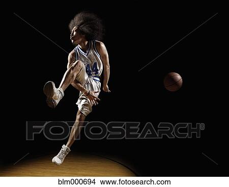 Picture - Mixed race basketball player passing basketball. Fotosearch