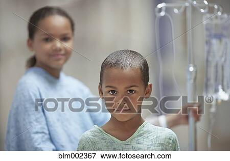 Stock Photo - Mixed Race boy and girl in hospital gowns. Fotosearch