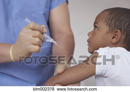 Stock Photo - Mixed Race boy getting shot at hospital. Fotosearch