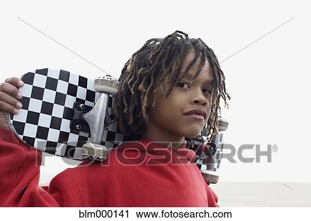 Mixed Race boy holding skateboard View Large Photo Image Stock Image - Mixed Race boy holding skateboard. Fotosearch