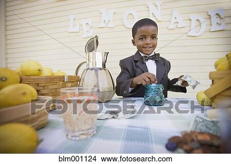 Picture - Mixed race boy in suit selling lemonade. Fotosearch