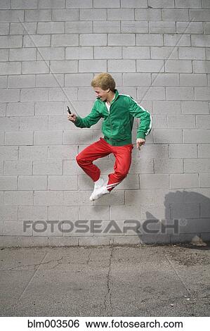 Mixed race boy jumping in mid-air using cell phone View Large Photo Image Stock Photograph - Mixed race boy jumping in mid-air using cell phone. Fotosearch