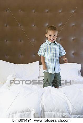 Mixed race boy jumping on bed View Large Photo Image Stock Image - Mixed race boy jumping on bed. Fotosearch