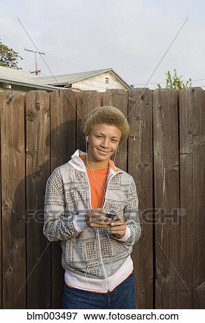 Stock Photo - Mixed race boy listening to mp3 player. Fotosearch