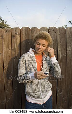 Mixed race boy listening to mp3 player View Large Photo Image Stock Photo - Mixed race boy listening to mp3 player. Fotosearch