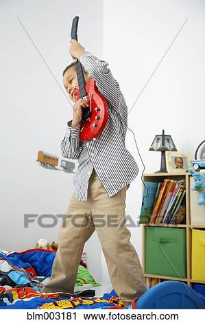 Mixed race boy playing toy guitar View Large Photo Image Stock Image - Mixed race boy playing toy guitar. Fotosearch