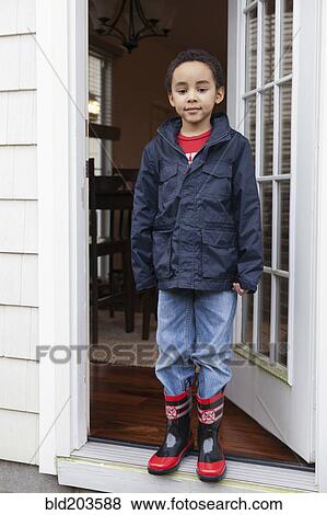 Mixed race boy wearing rainboots and jacket View Large Photo Image Stock Photo - Mixed race boy wearing rainboots and jacket. Fotosearch