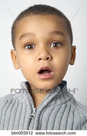 Stock Image - Mixed race boy with surprised expression. Fotosearch