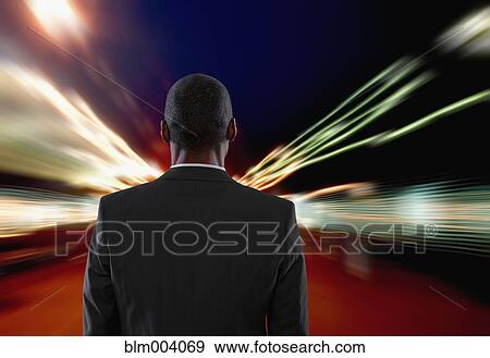 Mixed race businessman facing blurred city View Large Photo Image Stock Photo - Mixed race businessman facing blurred city. Fotosearch