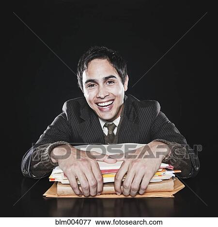 Stock Photo - Mixed race businessman holding stack of paperwork. Fotosearch
