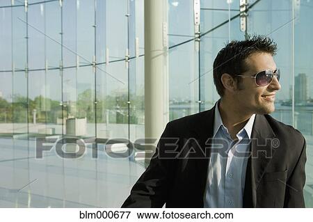 Stock Photo - Mixed race businessman in glass walled room. Fotosearch