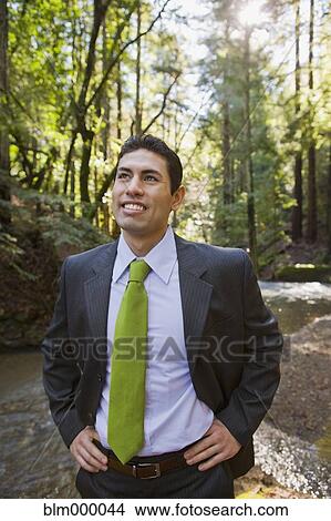 Picture - Mixed Race businessman in woods. Fotosearch
