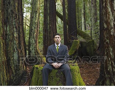 Stock Photo - Mixed Race businessman in woods. Fotosearch