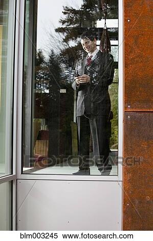 Mixed race businessman looking at cell phone View Large Photo Image Stock Photography - Mixed race businessman looking at cell phone. Fotosearch
