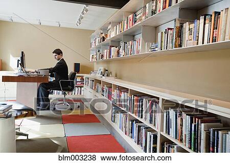 Stock Photo - Mixed race businessman sitting at desk. Fotosearch