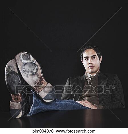 Stock Photo - Mixed race businessman sitting with feet up. Fotosearch
