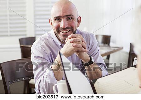 Stock Photo - Mixed race businessman smiling in cafe. Fotosearch