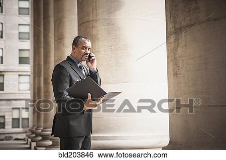 Mixed race businessman talking on cell phone View Large Photo Image Stock Photograph - Mixed race businessman talking on cell phone. Fotosearch