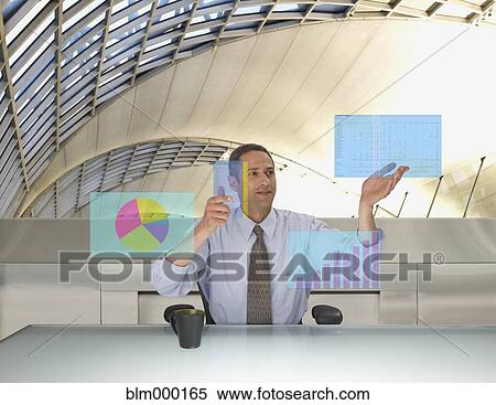 Stock Photography - Mixed Race businessman touching virtual interactive display. Fotosearch