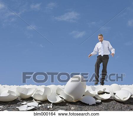Mixed Race businessman walking on egg shells View Large Photo Image Picture - Mixed Race businessman walking on egg shells. Fotosearch