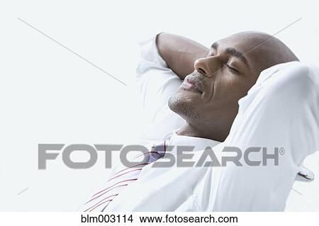 Mixed race businessman with hands behind head and eyes closed View Large Photo Image Picture - Mixed race businessman with hands behind head and eyes closed. Fotosearch