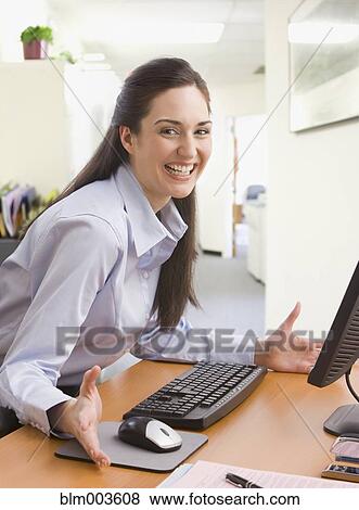 Mixed race businesswoman sitting at desk View Large Photo Image Stock Photo - Mixed race businesswoman sitting at desk. Fotosearch