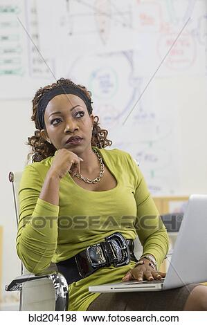 Stock Photo - Mixed race businesswoman thinking in office. Fotosearch