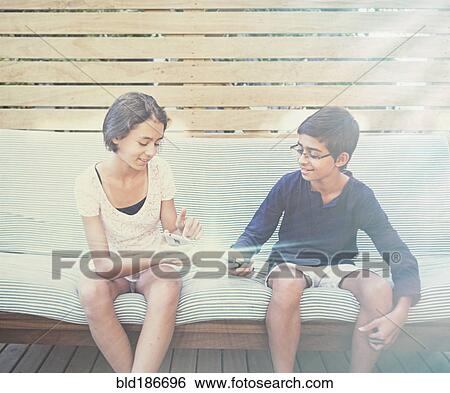 Stock Photograph - Mixed race children using glowing cell phones. Fotosearch