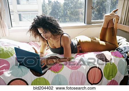 Mixed race college student using laptop in dorm View Large Photo Image Stock Image - Mixed race college student using laptop in dorm. Fotosearch